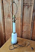 Full view of vintage white glass table lamp with metal base, harp, and fabric cord