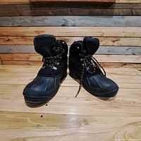 Pair of black winter boots front view showing lace-up front and rubber toe section.