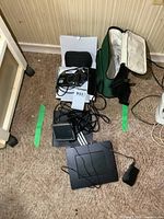 Lot contents including Nikon Coolpix camera, TomTom GPS device, and digital photo frame with accessories spread out on carpet.