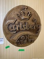 Front view of circular Carlsberg resin sign with three-dimensional crown and 'ON DRAFT' text