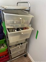 Metal-framed rolling cart with five translucent drawers containing beads and supplies