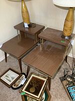 Pair of mid-century modern end tables with wood veneer tops, brass rods, angled legs, and lamps on top (lamps not included).