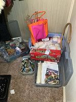Overview photo showing multiple totes containing yarn skeins, bead loom box, and craft accessories
