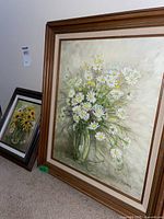 Photo showing the larger 20x16 framed painting of white daisies labeled 'Daisy A Day' by Marya Bordowitz.