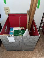 Collapsible storage box containing various acrylic paint sets by Reeves along with canvas boards and painting instruction books.