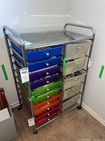 Front angle photo of the metal rolling storage cart showing both the colored plastic drawers on the left and clear plastic drawers on the right.