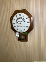 Front view of Schweppes Mixers wall clock showing octagonal wooden frame, Roman numeral dial, and pendulum section below