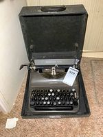 Front view of vintage Remington Rand manual typewriter in open black carrying case