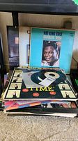 Photo showing a stack of vinyl records with Nat King Cole's 'Ramblin Rose' visible at top of the pile