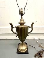 Vintage Chapman-style table lamp, showing the urn-shaped body with scrolled handles, mounted on black base, photographed against a plain background.