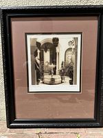 Front view of the framed sepia courtyard photograph showing the ornate black frame and double matting.