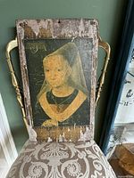 Front view of distressed vintage portrait of Renaissance-style woman printed on wood with cracking and peeling.