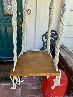 Photo of the square wooden shelf with thick cream macrame rope supports