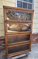 Front view of closed four-section bookcase showing leaded glass top and clear glass lower doors