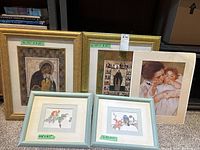 Five artwork pieces including three gold framed religious icons, two small framed bird illustrations, and one unframed mother and baby print.