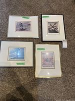 Four framed artwork pieces laid on carpet, showing variety of frame colors and artwork by Hazel Parker.