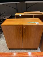 Front view of closed cabinet showing wood-grain finish and dual doors