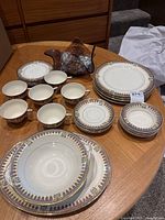 Overview of all ceramic dishes and decorative glass bowl on wooden table.