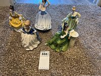 Five Royal Doulton female porcelain figurines positioned on carpet with identification sticker visible
