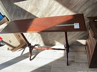 Solid wood hall table showing front and legs, with visible scratches on wood.