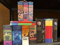 Front view showing a variety of Harry Potter books including paperback and hardcover editions stacked together on a shelf.