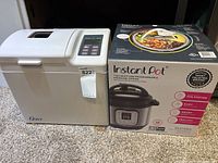 Instant Pot Duo Mini box and Oster breadmaker side by side on carpet