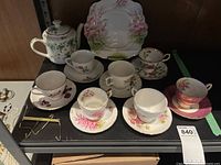 Full set showing 6 teacups and saucers, a teapot, and a square platter.