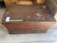 Top view of solid wood chest showing scratches, scuffs, and measuring tape label indicating dimensions W 37.5" x D 21" x H 19.5".