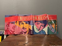 Front and back cover of The Beatles book featuring colorful pop art portraits of Beatles members by Andy Warhol style artwork.