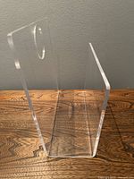 Front and side view showing the clear Lucite U-shaped magazine holder with circular hole on the side panel.