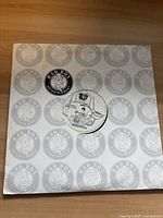 First vinyl LP record, white label with Bad Boy Entertainment logo and circular text, outer sleeve with repeated logo pattern