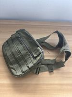 Front view of army carrying satchel showing MOLLE webbing and main zippered compartment