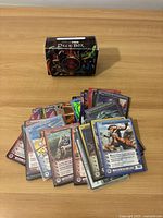 Colorful collection of Chaotic trading cards fanned out on a wooden surface, some cards have holographic elements.