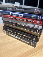 Stack of nine DVDs showing titles and spines clearly, some still sealed, some unsealed