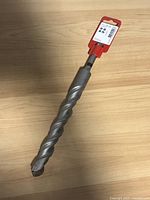 Hilti 7/8 inch concrete drill bit lying horizontally showing spiral design and tip.