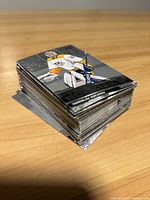 Stack of hockey cards showing front images of players including a goalie in yellow and white uniform.