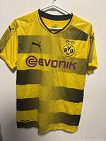 Front view of yellow and black Borussia Dortmund jersey with Puma and Evonik logos.
