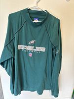 Full view of the green Eagles football sweatshirt with logos centered on front.