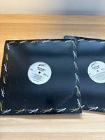 Photo showing two OutKast vinyl records in black sleeves with white and gold Lifes logos.