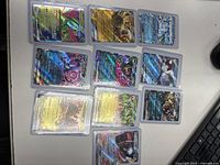 Ten Pokémon cards displayed face up in protective sleeves, showing holofoil and gold foil finish with various characters and EX/GX styles.