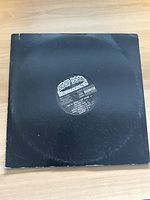 Black vinyl record in a black paper sleeve with visible wear, label displays Snoop Dogg Da Game Is To Be Sold, Not Told 1998 information and track listing.