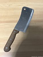 Full view of the Japanese cleaver showing wooden handle with three rivets and rectangular stainless steel blade.