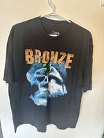 Front view of black vintage T-shirt showing blue skull graphic and 'BRONZE' text