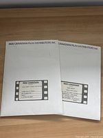 Two white envelopes or folders labeled Pan-Canadian Film Distributors Inc. with film strip graphics, containing the press kits.