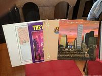 Five vintage LP album covers arranged side by side, showing various artists and colorful cover art.