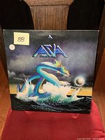 Front cover of the vinyl LP album showing dragon artwork and the band name Asia.