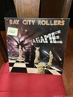 Front cover of Bay City Rollers "It's a Game" LP shows space-themed artwork with chess pieces.