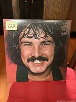 Front cover of Burton Cummings My Own Way to Rock LP showing a close-up smiling portrait of Burton Cummings with curly hair and mustache.
