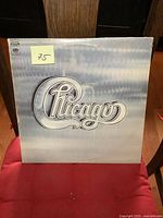 Front cover of Chicago II album with band logo on light blue and gray textured background.