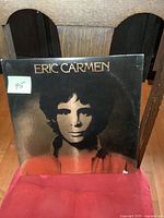 Front cover of the Eric Carmen vintage vinyl LP album showing black and white photo of artist and gold lettered name with minor wear and edge damage.
